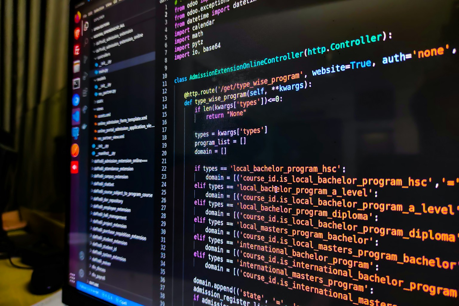 A developer looking intently at a multi-pane IDE showing code, a diff view, and an AI chat window, with a surfboard leaning against the wall in the background.